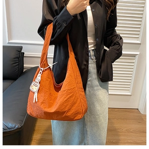 Detail of brick orange nylon tote bag with large capacity and cartoon knot charm