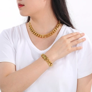 Close-up of 18K gold plated 13mm Cuban link necklace and bracelet set on model