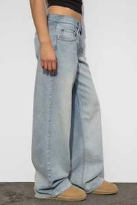 Vue latérale d'un jean vintage bleu délavé à taille haute et jambe large sur modèle