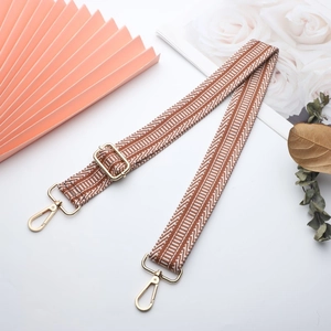 Detail of adjustable woven canvas strap with gold metal hooks and herringbone pattern