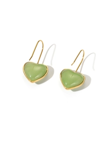 Detail of sweet green heart-shaped resin earrings with elegant golden metal hooks