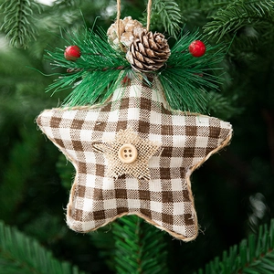 Close-up of star ornament with pine cones and red berries hanging on a Christmas tree