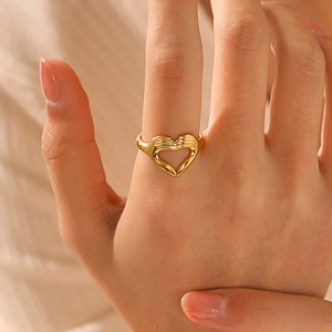Bague coeur en acier inoxydable plaqué or portée au doigt dans un style minimaliste épuré