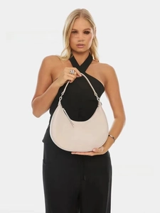 Detail of off-white half-moon shoulder bag with sleek silver hardware on a model