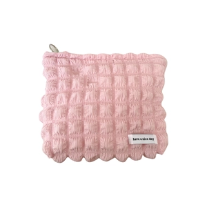 Pink candy bubble cosmetic bag with pleated texture and silver D-ring on white background