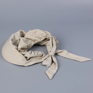 Detail of beige cotton sun hat with elegant rear bow tie and elastic back closure