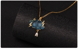 Detail of blue cloud pendant with golden lightning bolts and teardrop zircon on chain
