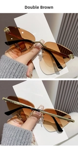 Detail of rimless cat-eye sunglasses with gold metal leopard decor and brown gradient lens