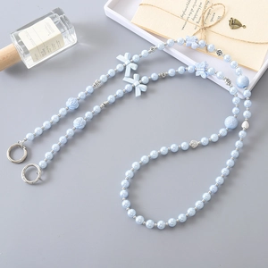 Blue acrylic pearl crossbody phone strap with butterfly and rose beads on grey background