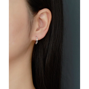 Close-up of S925 silver hoop earrings with pave cubic zirconia worn by a model
