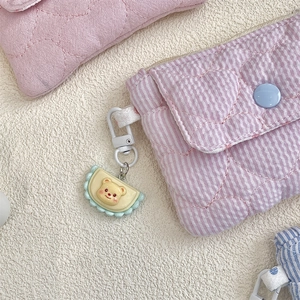 Macro detail of quilted heart pattern on pink striped wallet with cute bear charm