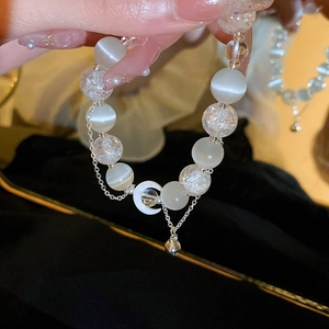 Detail of moon pendant and opal beads on a luxury beaded bracelet with silver chain