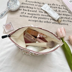 Vue détaillée d'une trousse à maquillage fleurie rose montrant sa grande capacité de rangement