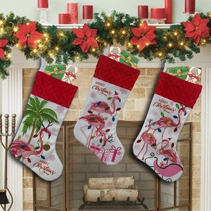 Detailed view of three flamingo Christmas stockings hanging on a festive fireplace mantel