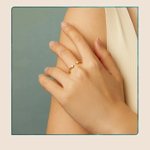 Detailed view of an adjustable gold ring featuring two sparkling round moissanite stones