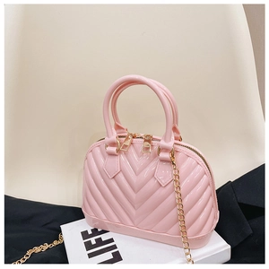 Detailed view of pink jelly Boston bag with gold chain strap on minimalist background