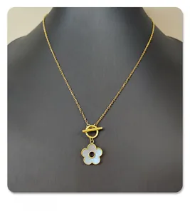 Detail view of titanium flower necklace with white shell inlay and gold-tone OT toggle clasp