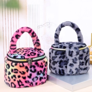 Macro view of plush leopard print cylindrical vanity bags in pink and grey tones