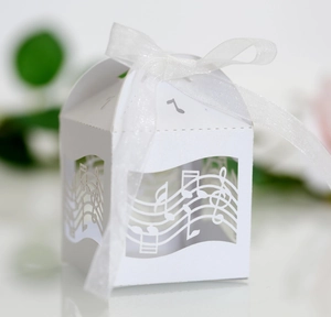 Détail d'une boîte cadeau blanche avec notes de musique découpées et ruban