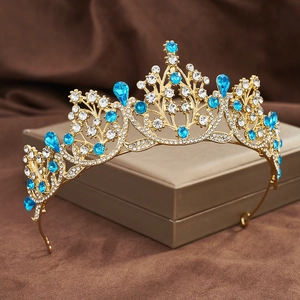 Macro shot of gold tiara with blue teardrop crystals and clear rhinestones on a box