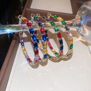 Macro detail of luxury C-hoop earrings featuring four rows of colorful gemstone inlay