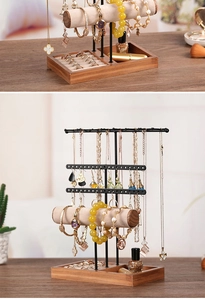 Macro view of multi-layer jewelry organizer with wooden base and metal necklace hooks