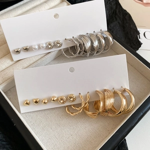 Detailed set of gold and silver heart earrings and textured hoops in a jewelry box