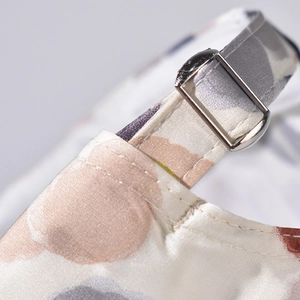 Detail view of smooth satin strap with silver adjustment buckle and colorful dot pattern