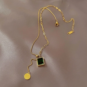 Gold-plated dual-chain necklace featuring an emerald green pendant and lobster clasp