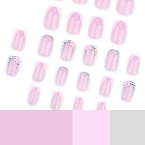 French pink press-on nails set with glitter borders, 3D floral accents, and sparkling rhinestones