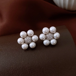 Macro detail of French vintage floral stud earrings with pearls and zircon stones