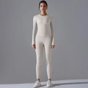 Vue d'ensemble d'un ensemble de yoga blanc à manches longues avec legging taille haute et col rond