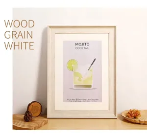 Détail du cadre en bois blanc avec affiche Mojito sur une table en bois rustique