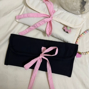 Détail de pochettes en tissu avec cordon rose et accents floraux 3D en noir et blanc