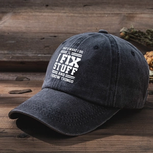 Detail shot of washed dark grey baseball cap with printed fix stuff slogan on wooden surface