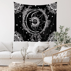 Detailed view of bohemian sun and moon tapestry hanging above a modern living room sofa