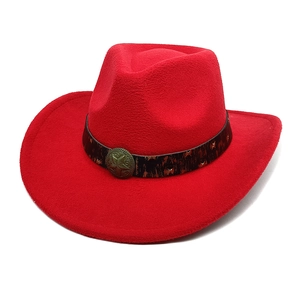 Détail d'un chapeau de cowboy en feutre rouge avec bande vintage et boucle étoile en métal