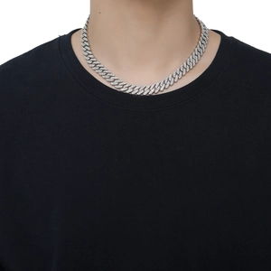 Nahaufnahme einer 12 mm silbernen Cuban Link Kette mit Kristallen an einem Model
