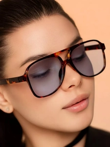 Close-up of tortoise shell sunglasses with double bridge and purple gradient lenses