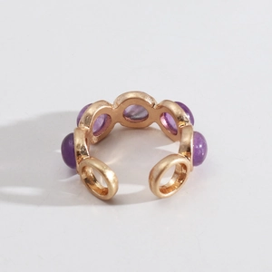 Détail d'une bague dorée ajustable avec cinq pierres violettes rondes en vue macro