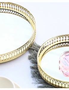 Detail of round gold metal mirrored trays with ornate cutout patterns and elegant finish