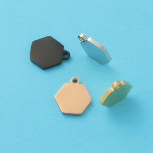 Close-up of four hexagonal stainless steel pendants in black, silver, rose gold and gold