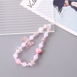 Detailed macro of pink acrylic bow and heart beads with iridescent square beads charm