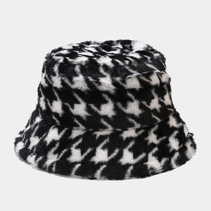 Close-up detail of soft black and white houndstooth plush texture on a winter bucket hat