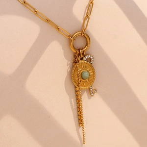 Detail of 18K gold plated paperclip necklace with sunburst pendant and crystal key
