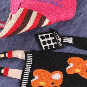 Embroidered cartoon girl patch with pink accents and HUALL lettering on navy fabric