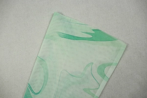 Detailed macro of breathable green mesh fabric featuring abstract textured prints