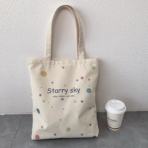 Détail du cabas en toile blanc cassé avec pois colorés et texte Starry Sky