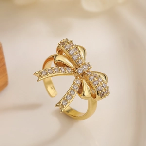 Macro shot of 18K gold plated bow ring with sparkling zircon stones and detailed texture