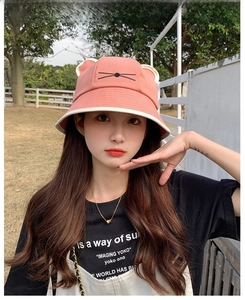 Detail of cute 3D cat ears and embroidered whiskers on a pink cotton sun hat